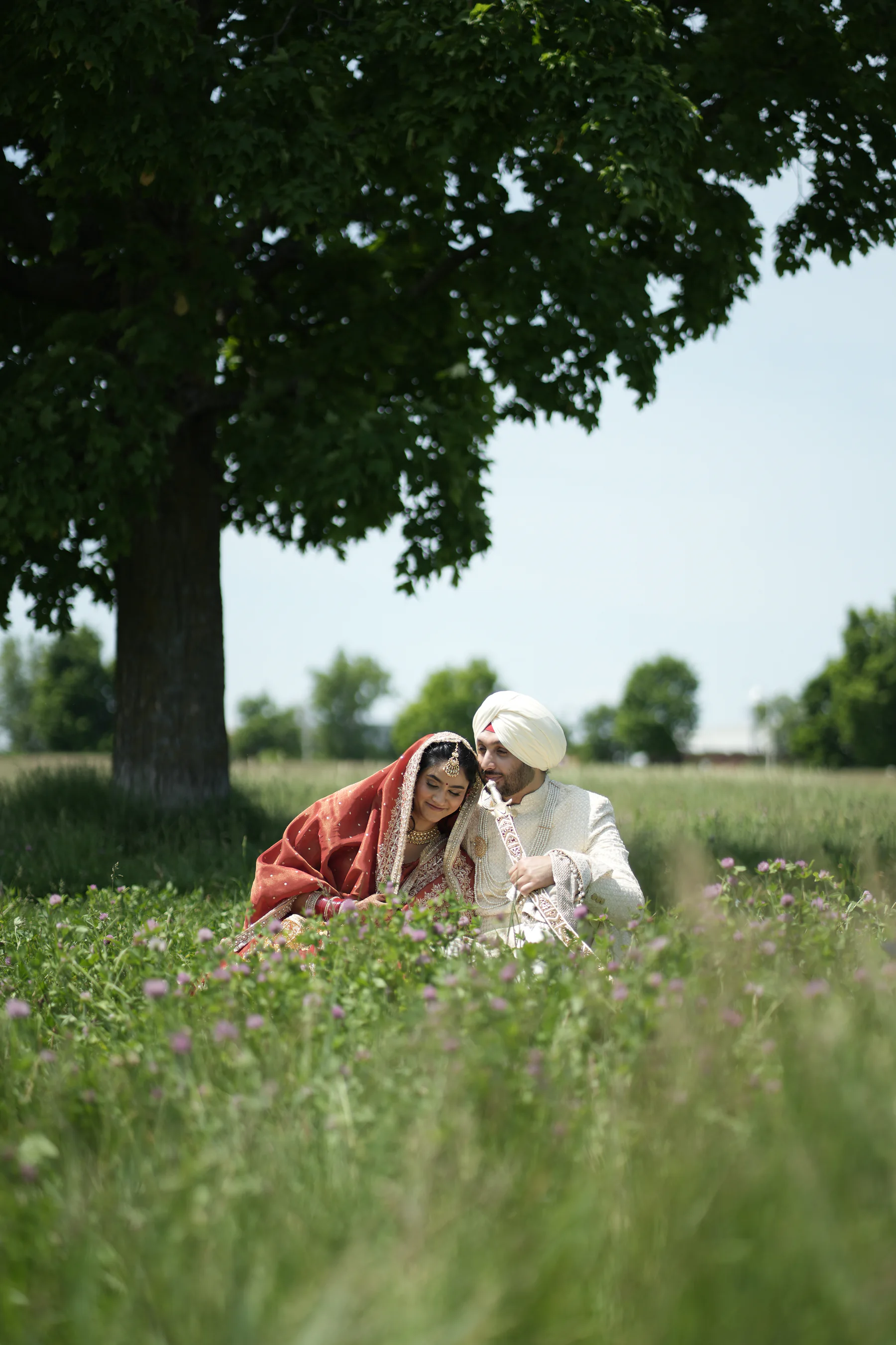 Wedding couple sitting together in a meadow